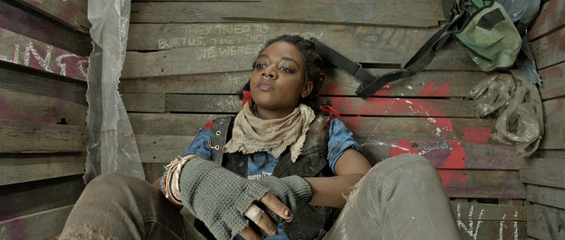 Woman in punk clothing looks pensively off-camera
