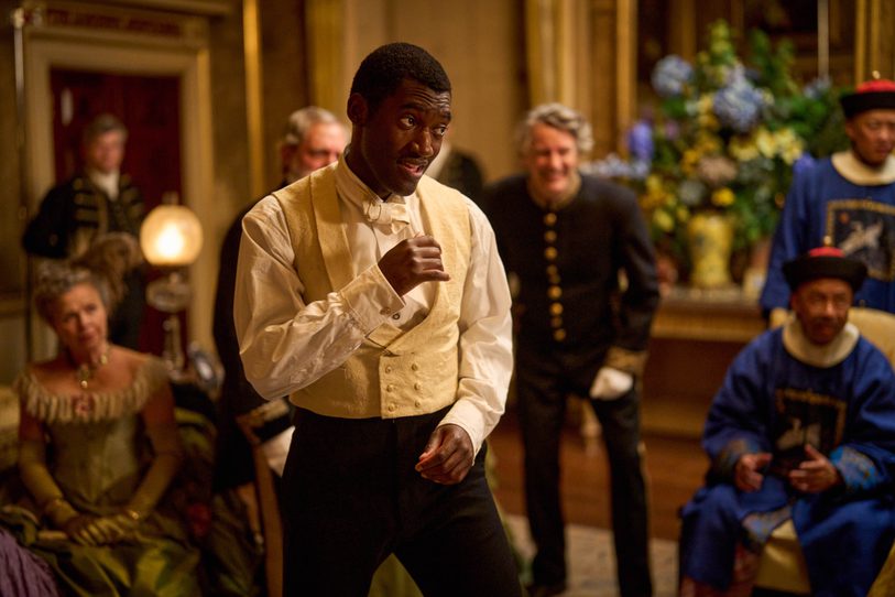 A man in suit attire does a boxing stance