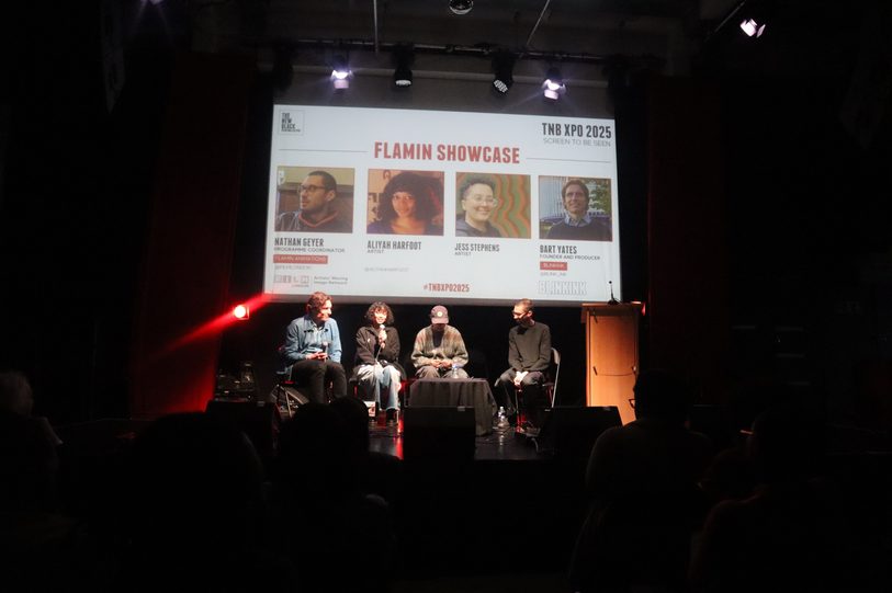 Four people sat on stage in front of screen at TNB XPO