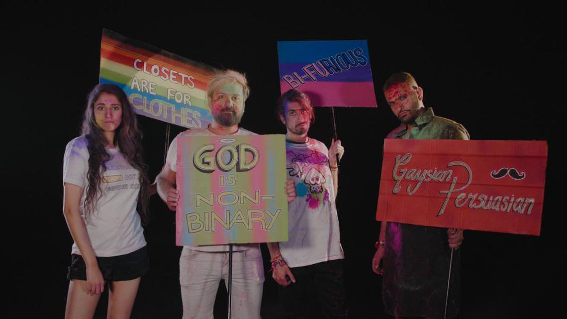 Still from Pride & Protest, directed by Blaise Singh - one women and three men holding placards on a black background