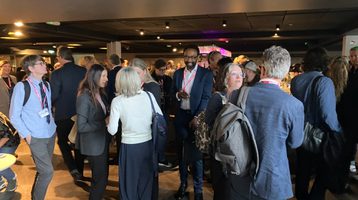 Group of people standing and talking at networking reception