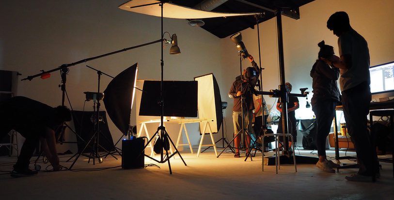 image of a film studio with people operating cameras and lights